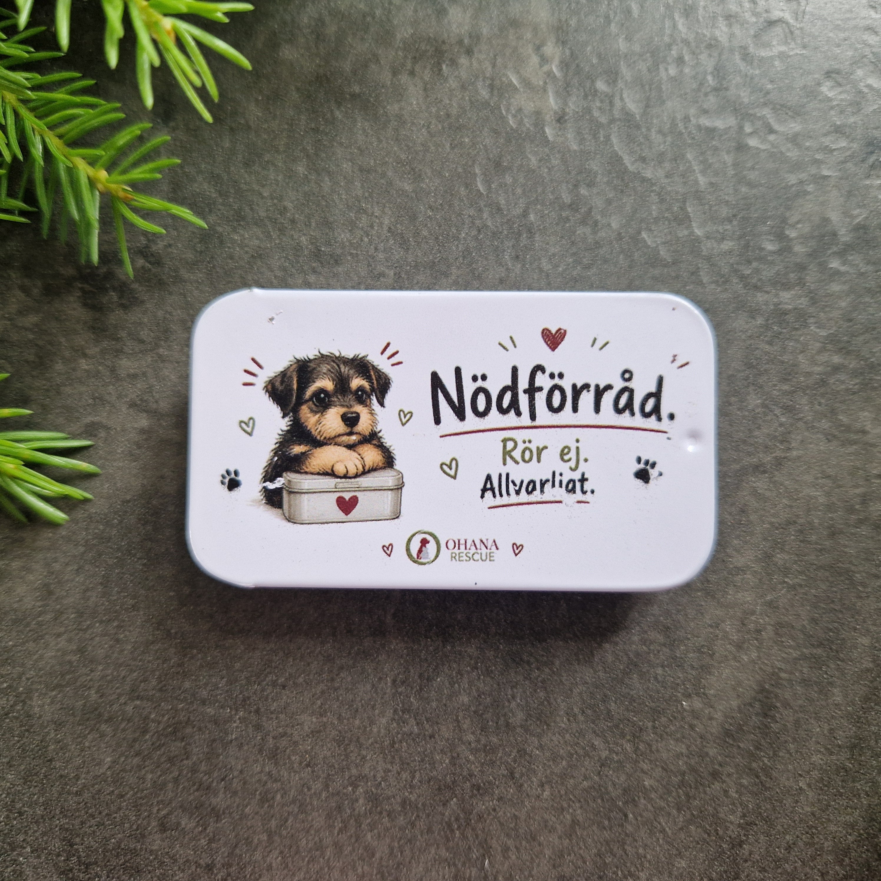 Närbild på liten plåtask med texten Nödförråd. Rör ej. Allvarligt.